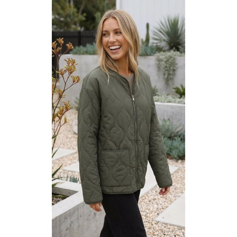 Donna sorridente con giacca trapuntata verde oliva