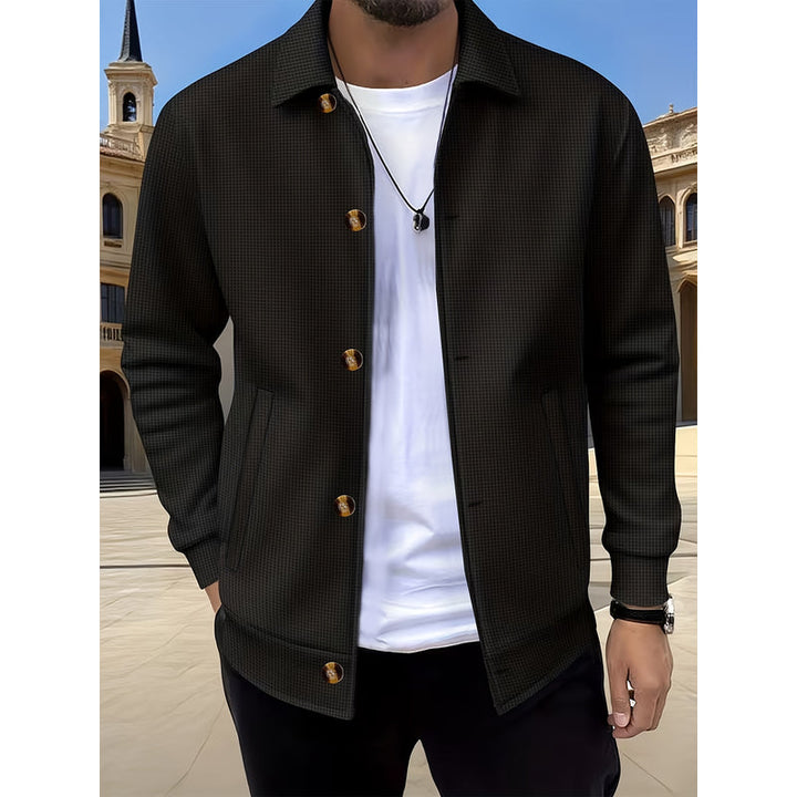 Uomo con giacca nero aperta su t-shirt bianca