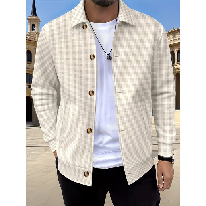 Uomo con giacca cachi aperta su t-shirt bianca