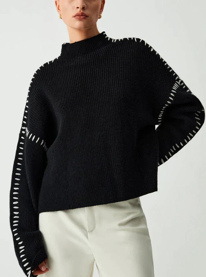 Donna che indossa il maglione nero con cuciture bianche