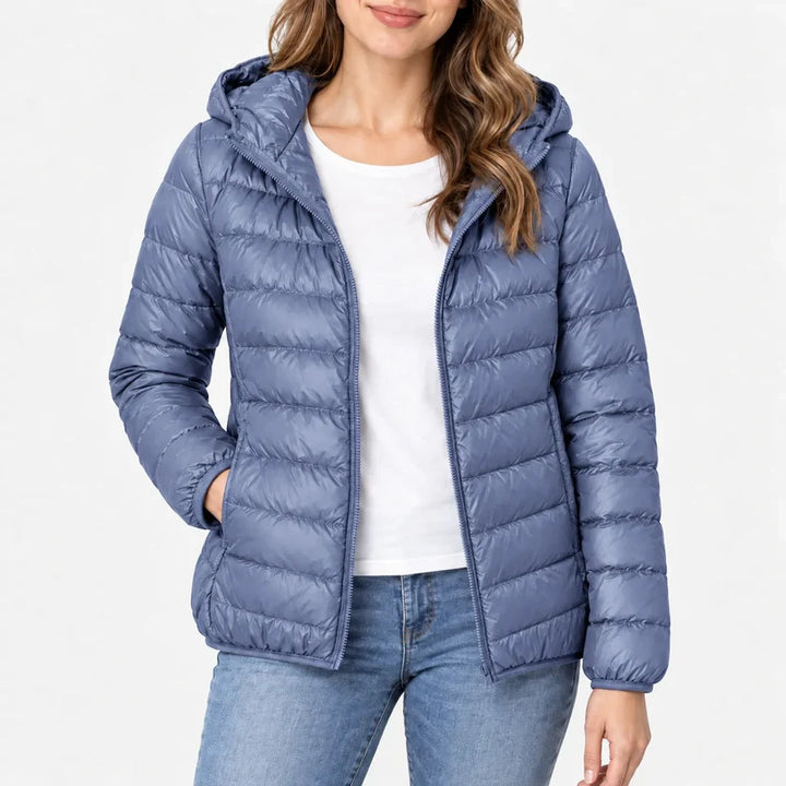Piumino da donna blu polvere con cappuccio e zip indossato