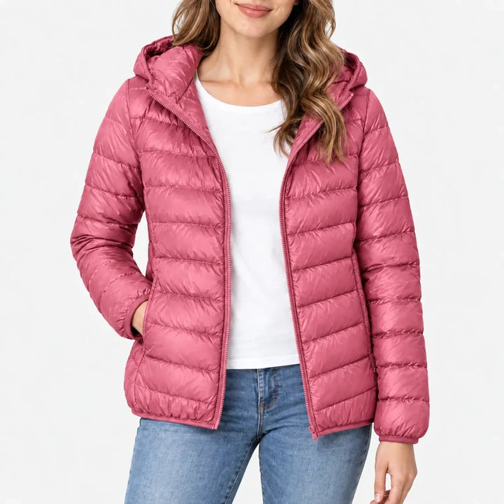 Piumino da donna rosa antico con cappuccio e zip indossato