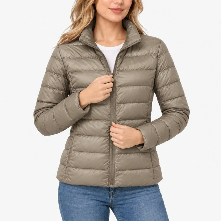Piumino da donna beige con collo alto e zip indossato