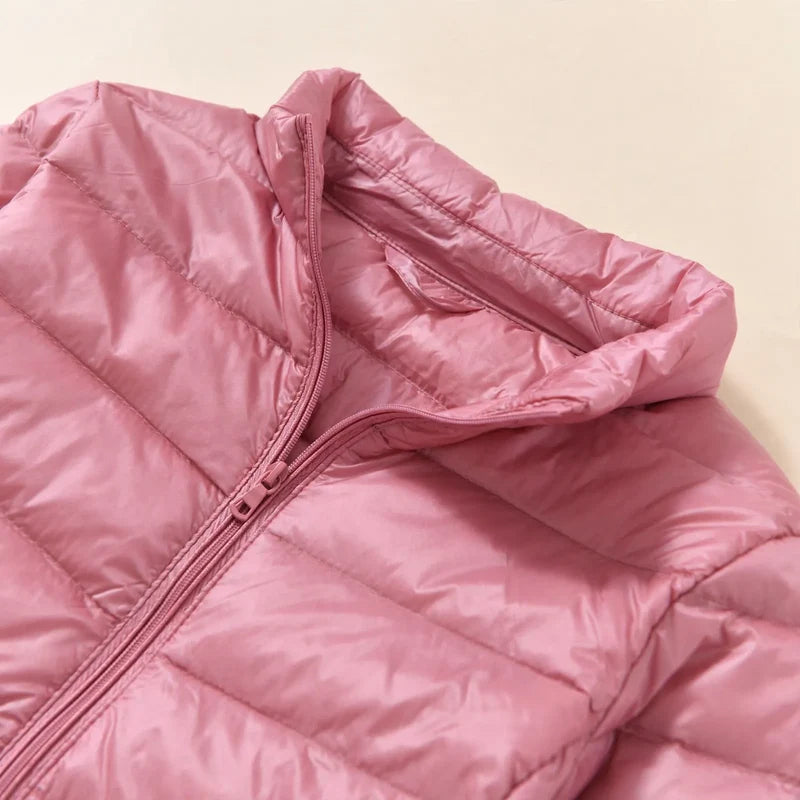 Dettaglio del collo alto e della zip del piumino da donna rosa